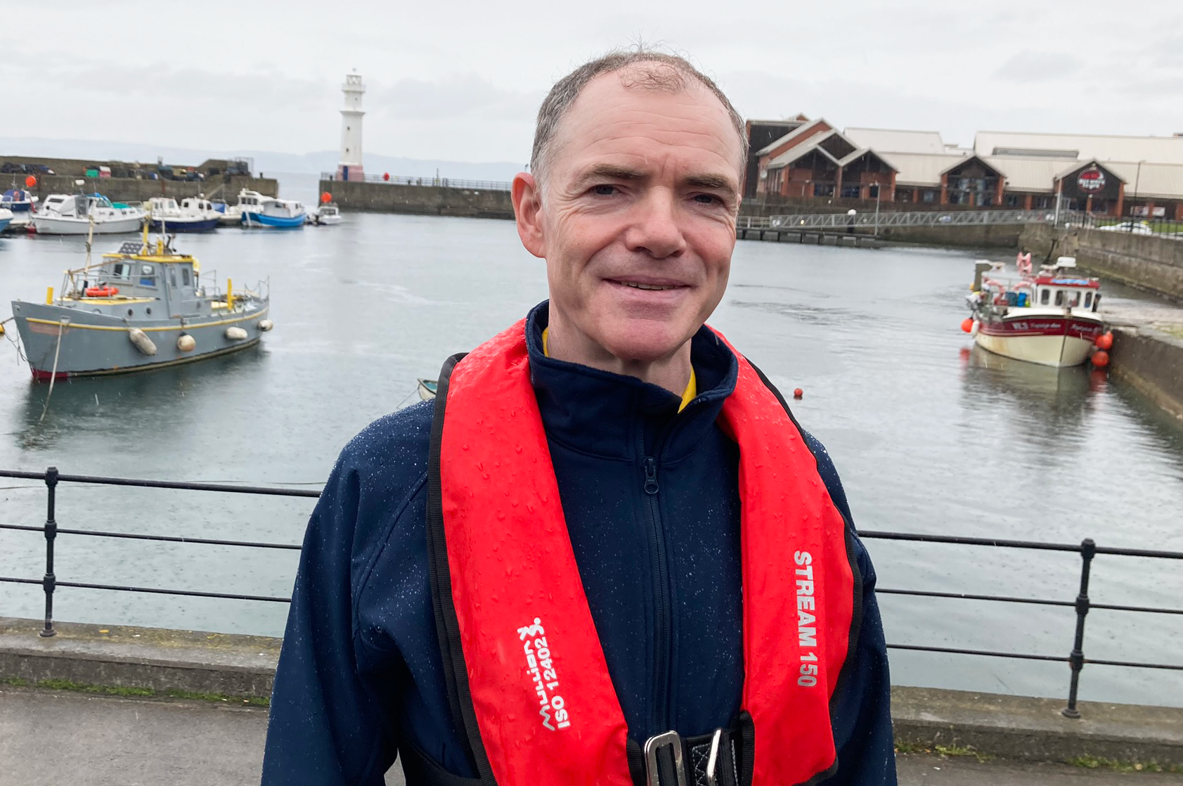 Field Researcher Jim at a harbour in front of fishing boats.