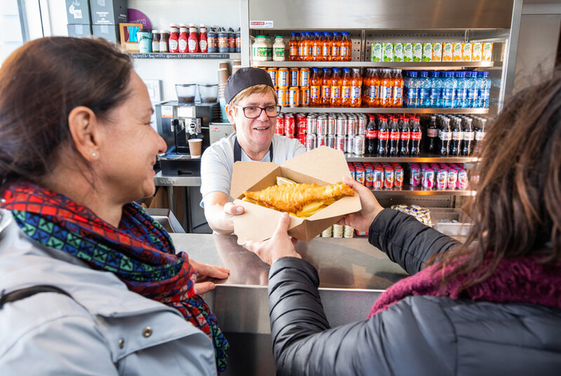 People buying a takeaway of fish and chips