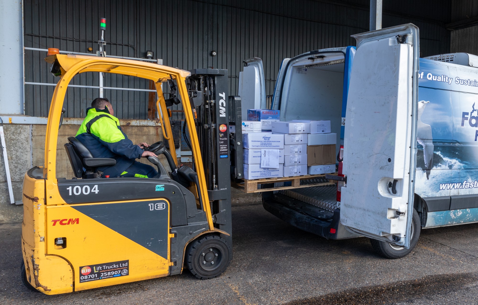 a forklift loading a pallet in a van