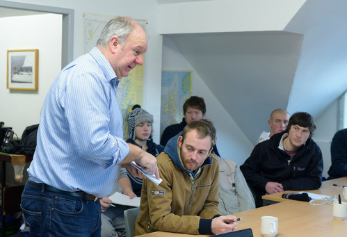 A group of fisherman in a classroom participating in onshore training