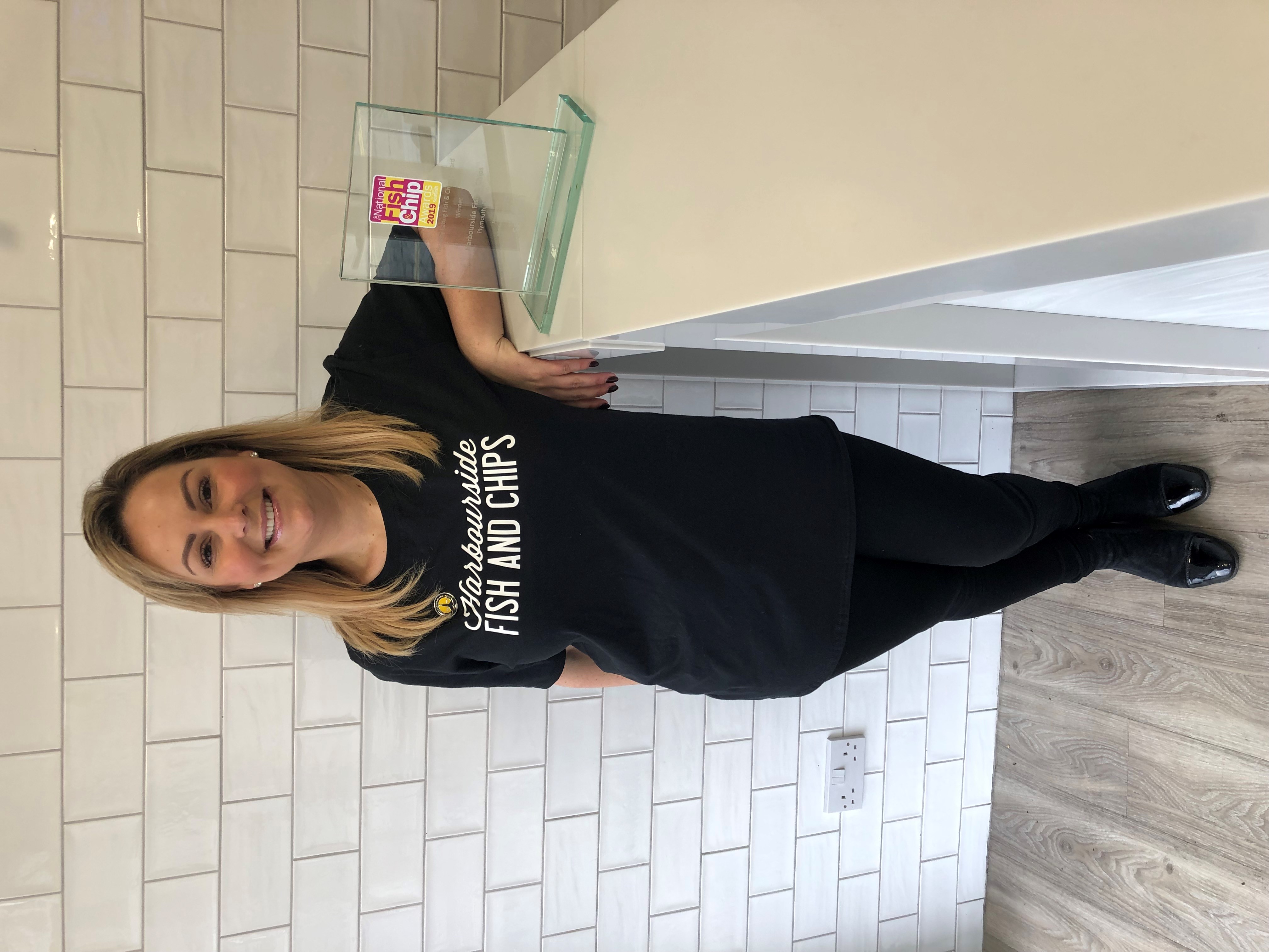 Sarah Lock, owner of the Harbourside, standing next to her award