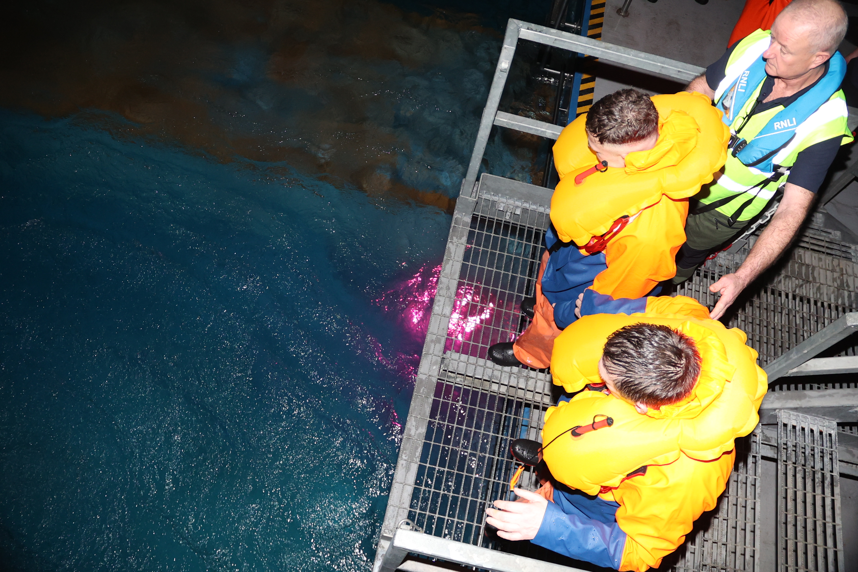 Fishers stand on a platform ready to enter the environmental pool which mimics tough conditions at sea.