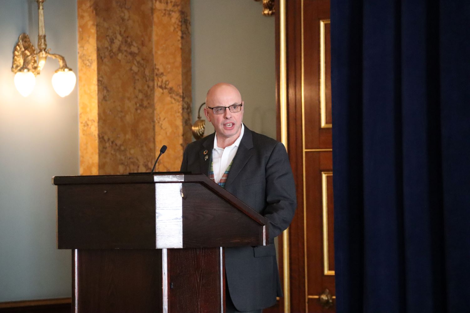 Seafish Head of Responsible Sourcing, Stuart McLanaghan stands behind a podium delivering a presentation.